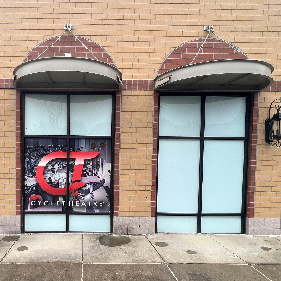 Commercial window tinting film applied on a building with visible signage.