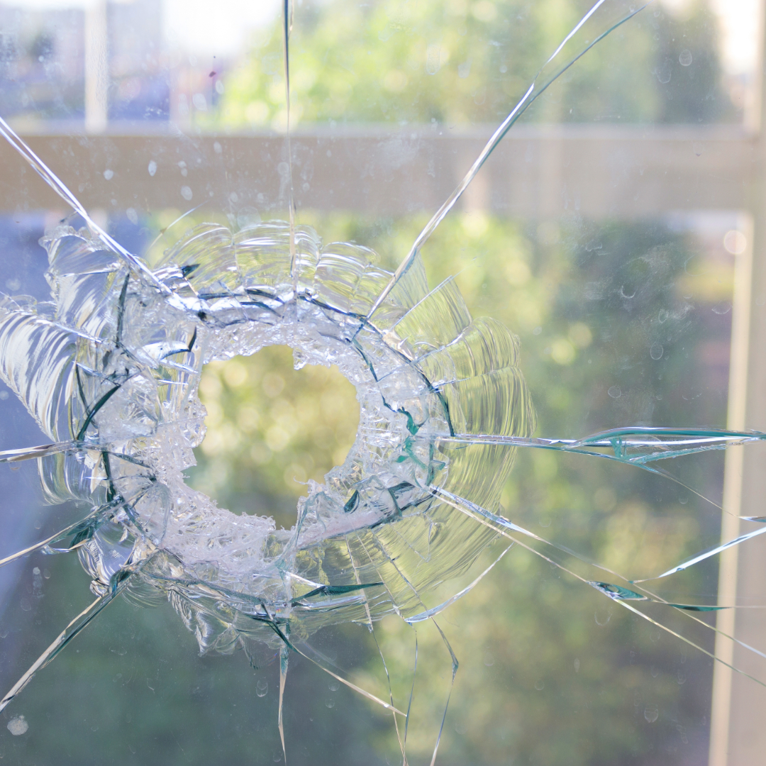 Broken window showing how residential window tint film can help reduce storm-related glass damage.